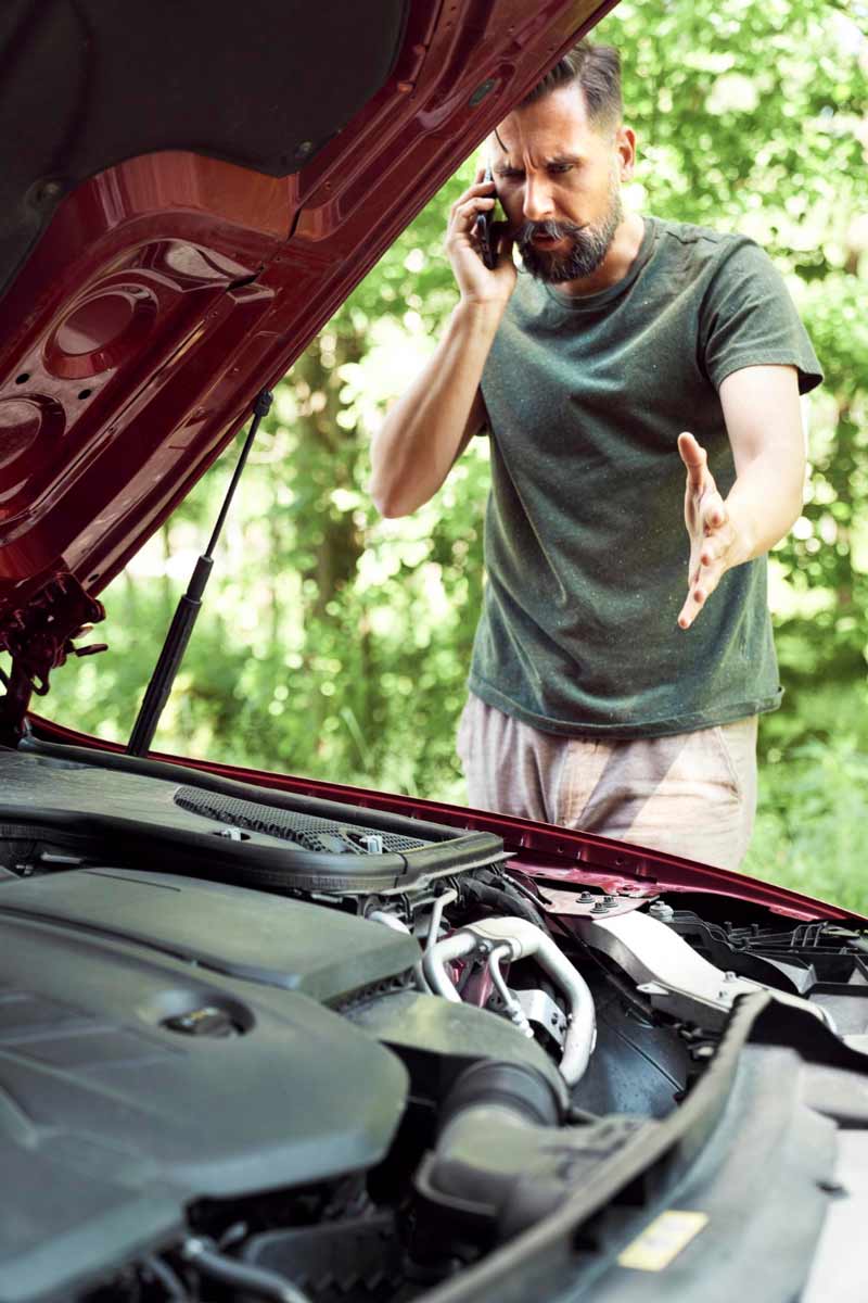 Junger Mann prüft Getriebeschaden bei Schrottauto Ankauf Kaiserslautern